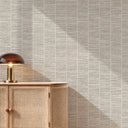 Modern entryway with light beige grasscloth wallpaper, wood console, decorative vases, and indoor plant.
