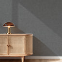 Limewash texture wallpaper in cool dark gray, featuring subtle tooling marks for a naturalistic, architectural feel in living spaces.