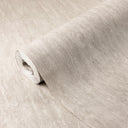 Beige vertical shimmer plaster wallpaper features a delicate sheen and brushed texture. The subtle sueded nap and vertical strokes add depth and luminosity, ideal for bedrooms or feature walls. Adhesive application required, perfect for modern interiors seeking subdued luxury.