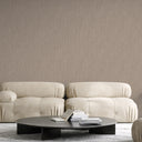 Warm brown striated wallpaper with fine directional texture and subtle metallic light play along the vertical lines. The refined linear surface adds height and movement to hallways and narrow spaces. Requires adhesive application.