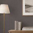 A linen-textured wallpaper in smokey taupe, featuring a balanced mix of horizontal and vertical scoring. Suitable for hospitality spaces or corridors, it provides a quiet, understated texture. This eco-friendly, strippable wallpaper is made in the USA and requires adhesive.