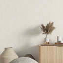 White shiny limewash wallpaper featuring irregular plaster marks with selective sheen. This removable wall mural offers a soft, luminous finish perfect for hotel lobbies or elegant dining areas, providing a gently reflective artisanal backdrop.