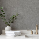 Graphite and dove gray tweed wallpaper with contrast specks, providing a uniform pattern that reveals fine linear detail upon closer inspection.
