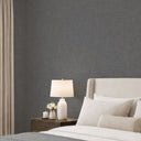 Close-up of dark gray limewash wallpaper, showcasing subtle tonal variations and brush marks for an organic, tactile ambiance.