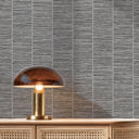 Close-up of gray grasscloth wallpaper showing the tactile grid pattern in taupe-gray with pale highlights. Perfect for boutique hotels and restaurant zones needing a natural, artisanal touch.