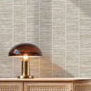 Natural grasscloth wallpaper in beige with irregular slubs and darker flecks, adding warmth and tactile interest to bohemian spaces.